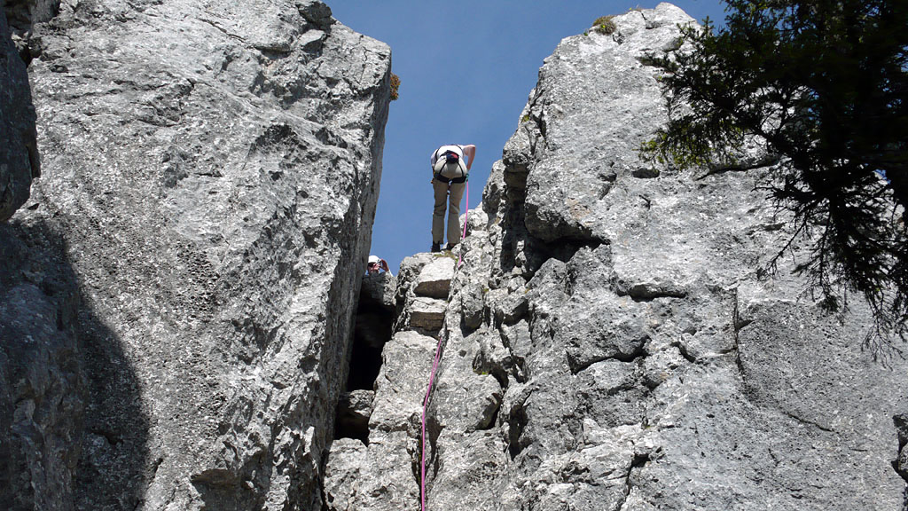 planken_110.JPG - Das 60m Seil um den Sockel vom Gipfelkreuz gewickelt gibt eine gute Abseile bis ans Ende der Rinne. Der komplett marmorierte Kamin wäre im Abstieg mehr als ekelhaft.