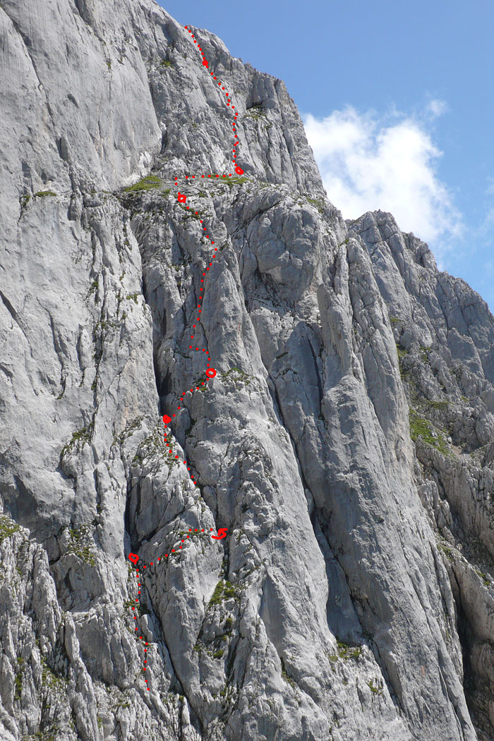 toerlwand_090.JPG - Die erste SL laut Topo muss auf zwei aufgeteilt werden (Stand selber bauen). Wir hatten enorme Probleme mit dem Seilzug. Das ausgesetzte Querband geht rechts ums Eck in die Rinne (Pfeil). Diese Stelle ist auch im AV-Führer "Kaiser extrem" falsch eingezeichnet. Hier ist der Geländeinstinkt gefragt. Ein neuer Ringbohrhaken steckt beim "schwarzen Kamin", lt. Topo ist hier kein Standplatz. Wir haben trotzdem einen gemacht. Der ist wohl als Abseilhaken gedacht, damit man über die Route runterkommen kann, was mit Doppelseilen tatsächlich funktionieren könnte, weil an der Terasse und am Gipfelgrat auch je ein Ring gebohrt ist.